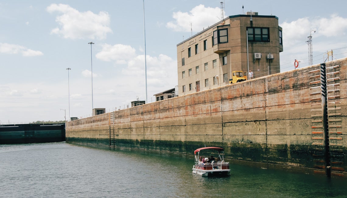 A pontoon boat in the Ohio River with the massive Willow Island locks