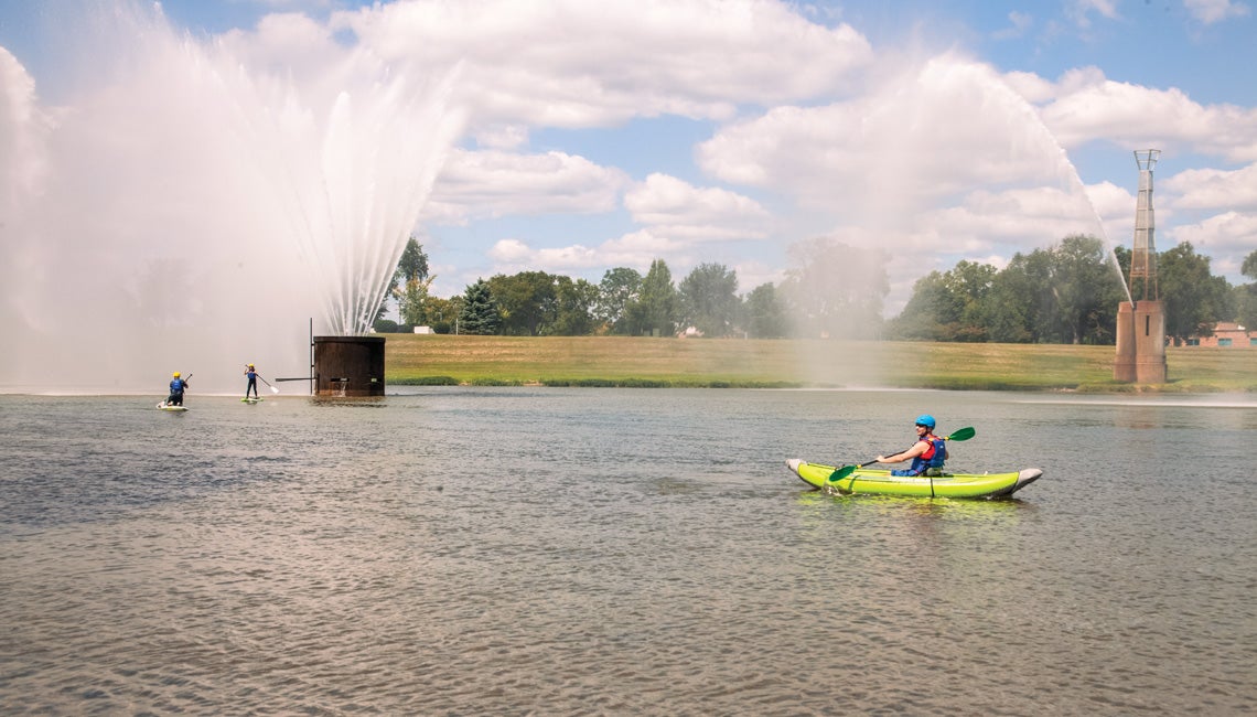 People paddle boarding and kayaking on a river