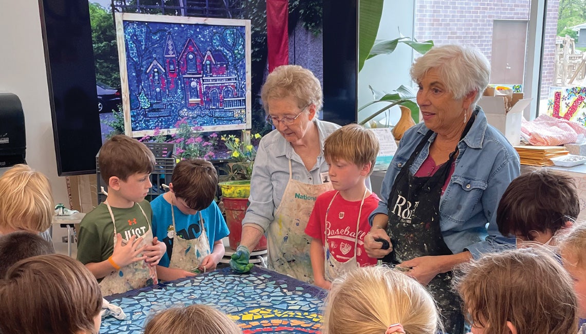 Two women teaching an art class with children