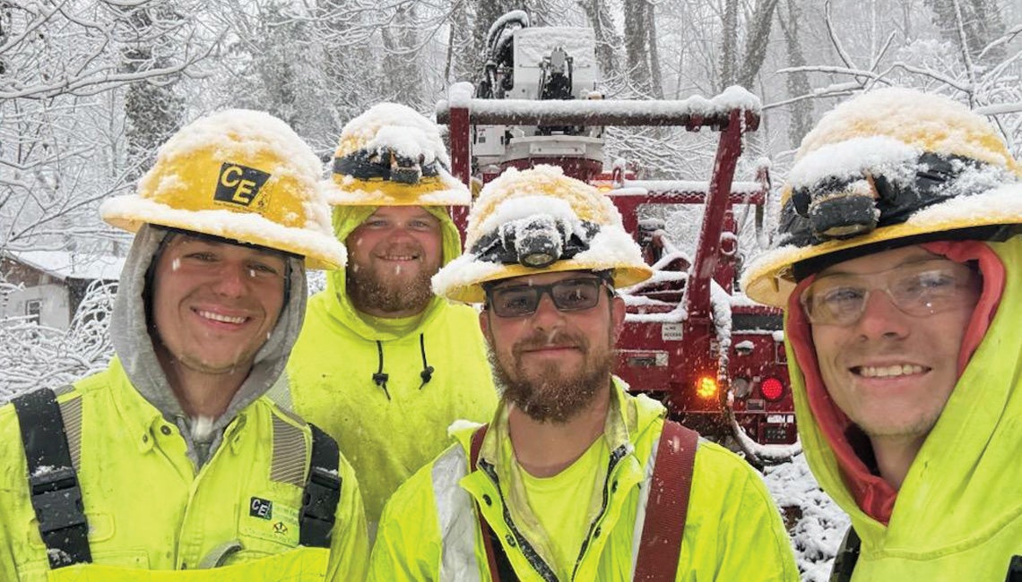 A group of electric lineworkers posing for a selfie in the snow