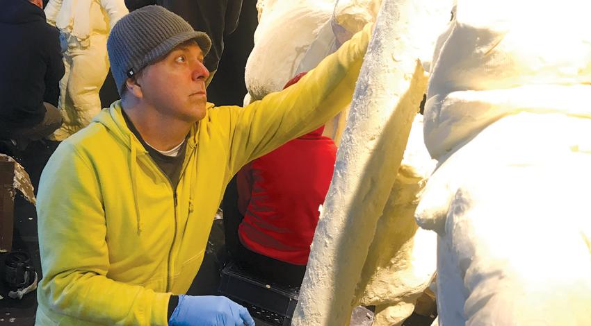 A sculptor working on their butter sculpture.