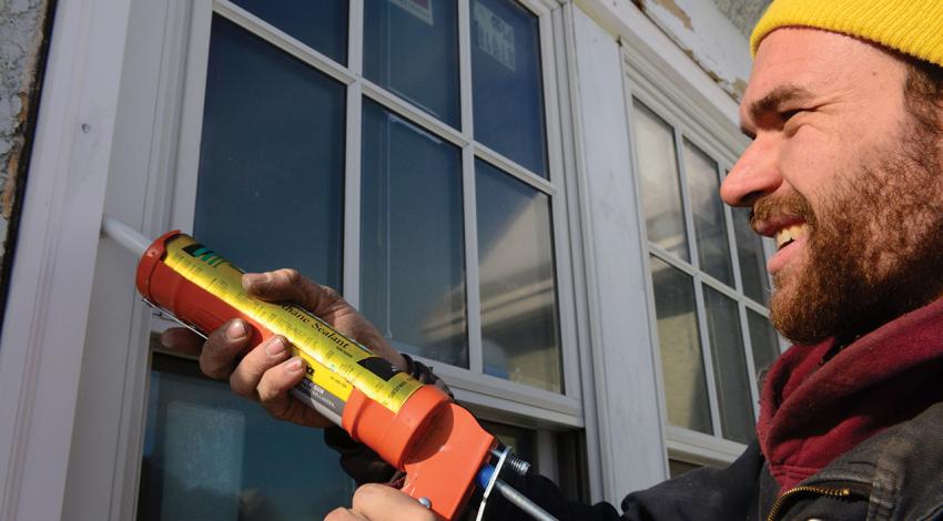 A man seals a window.