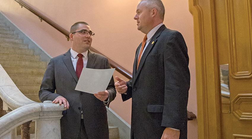 Marc Armstrong and Spencer Waugh talk on a staircase.