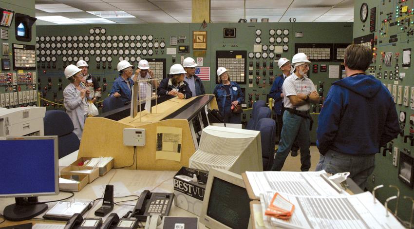 A group tours a room in a power plant.