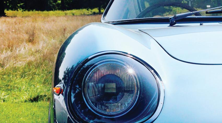 A close-up of an older car's headlight.