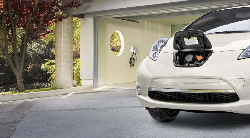 A picture of a parked, white Nissan LEAF