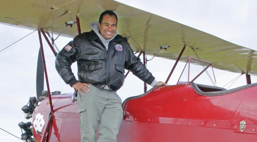 Dewey Davenport stands on the wing of a plane awaiting a passenger.