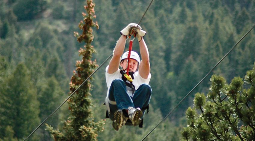 An individual smiles ziplining