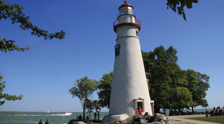 A photo of Marblehead Lighthouse surrounded by people and Lake Erie in the background