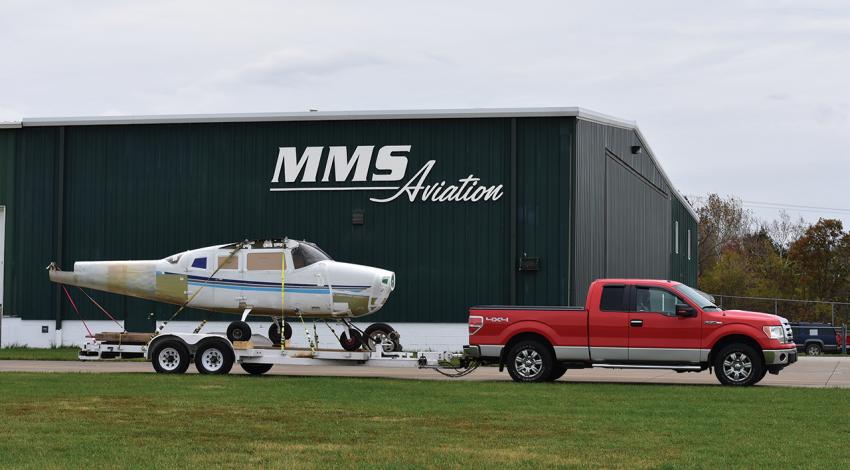 A truck pulls a small plane on a trailer outside of MMS Aviation.