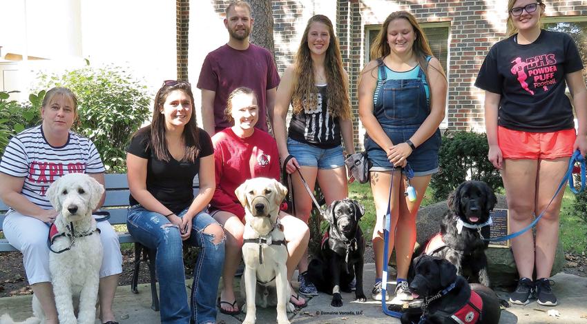 Polar Paws volunteers show off their trainees for the group’s founder, Matt Sutton.