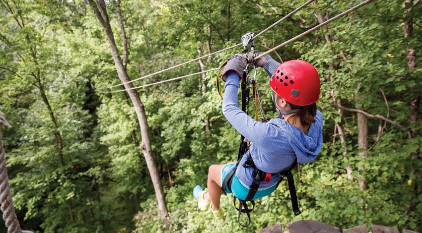 A person ziplining through the forest