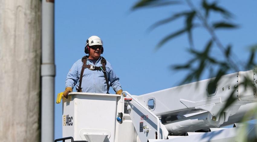 A lineworker stands in a bucket truck.