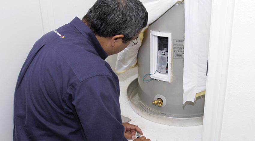 A man examines a water heater