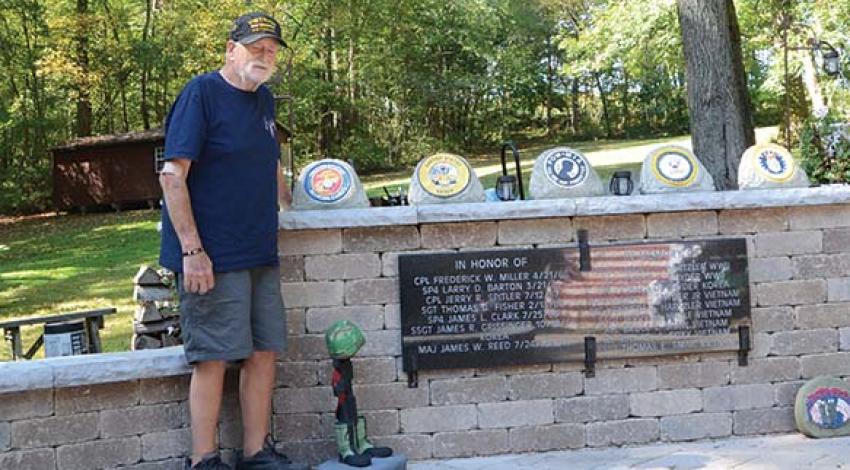 Gary Snyder pictured with a bronze plaque honoring his comrades