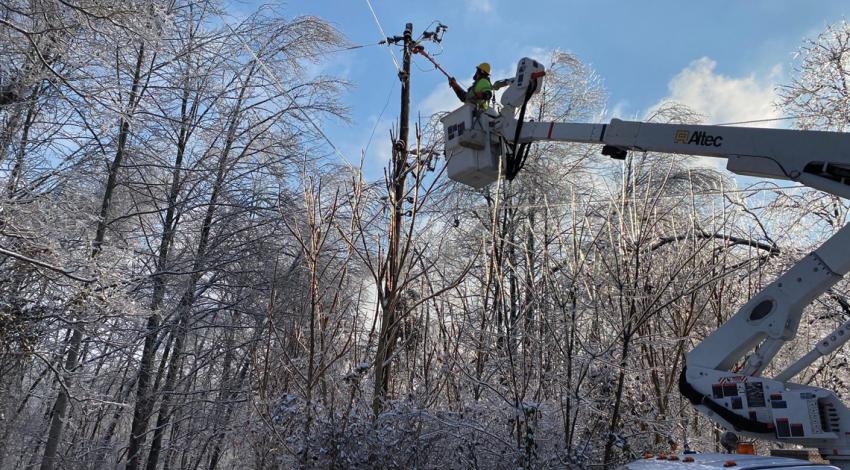 Lineworkers operating in icy, snowy weather.