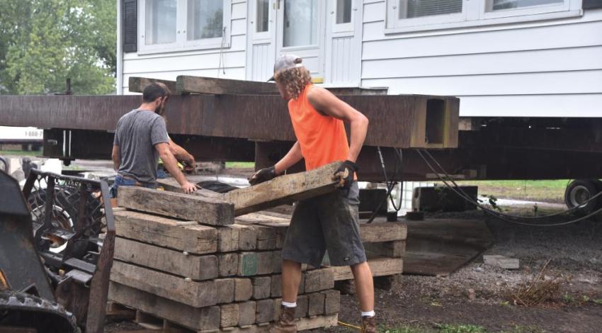 Experienced Klier crew members place long steel beams beneath a structure, then slowly raise it.