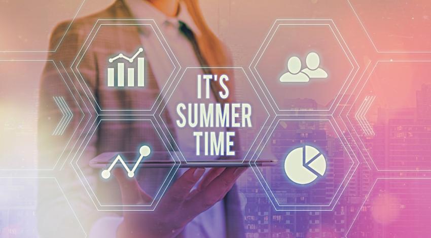 A hand holding a tablet with virtual text hovering above "It's summer time"
