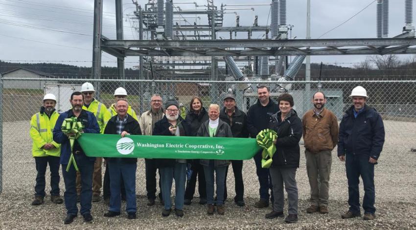 A group of people at an electric substation ribbon cutting