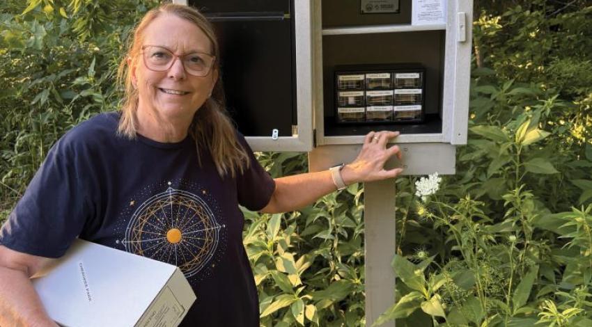 A woman standing with a community seed library