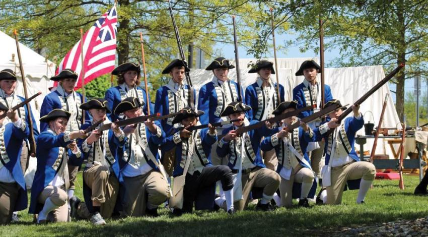 A group of students doing a Revolutionary War reenactment
