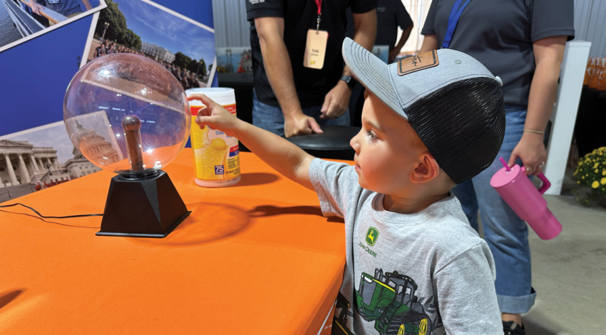 A little boy playing with an electric globe on a table