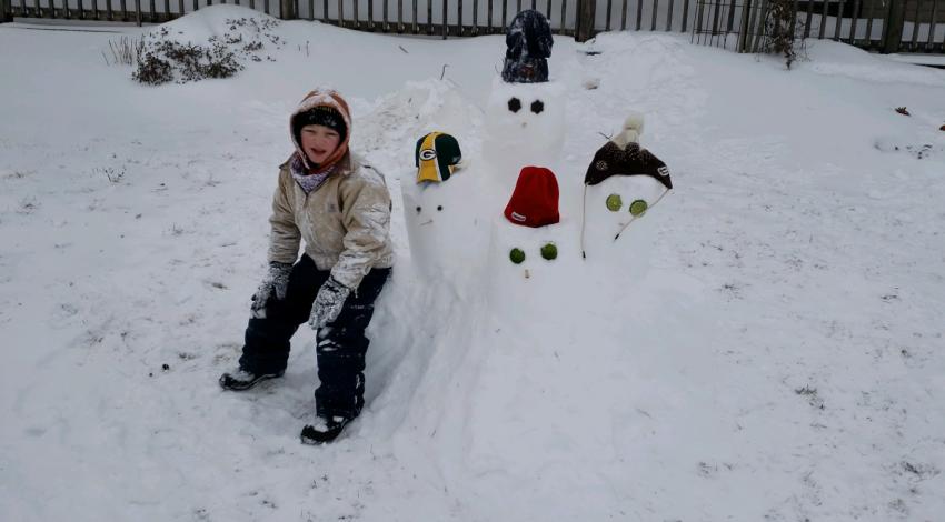 Child in the snow with snowmen