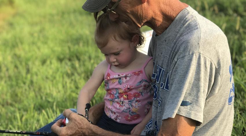 little girl fishing with her grandpa
