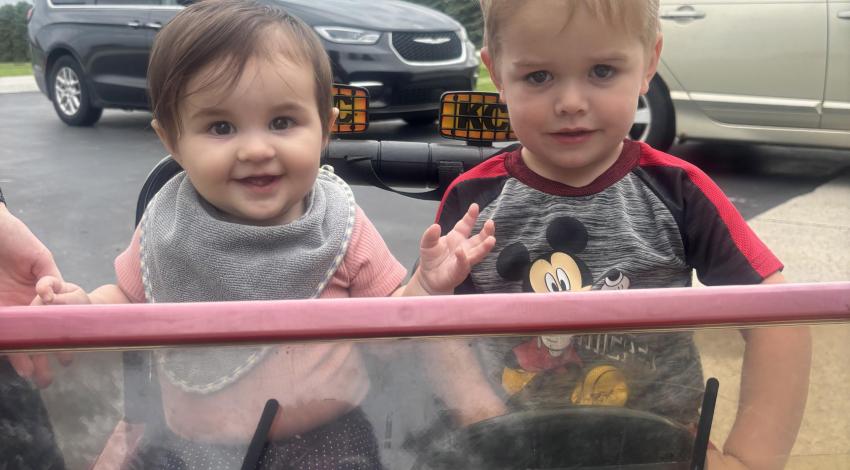 two small children in toy Jeep