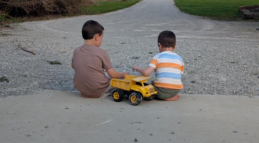 two boys playing with toy truck