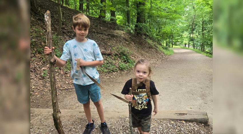 two children walking in the forest