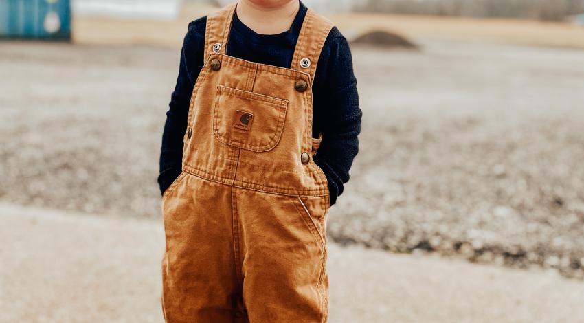 boy in overalls outside in winter