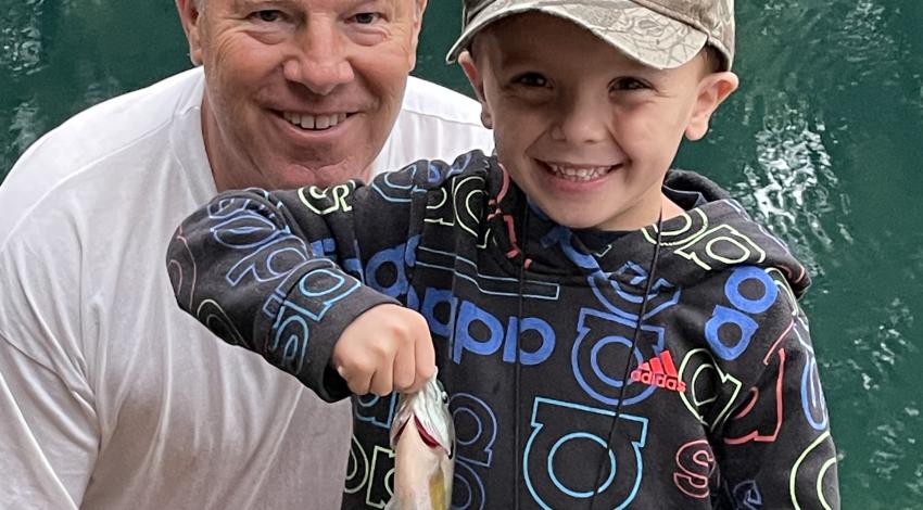 little boy and his grandpa holding a fish