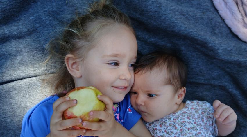 little girl and baby lying together