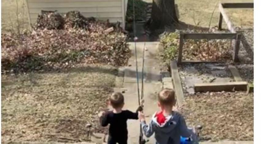 two little boys carrying fishing poles and a tackle box