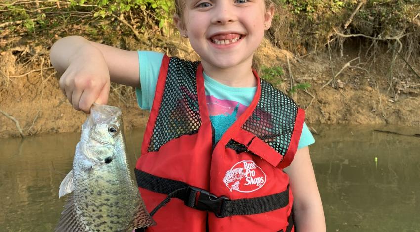 girl smiling holding fish