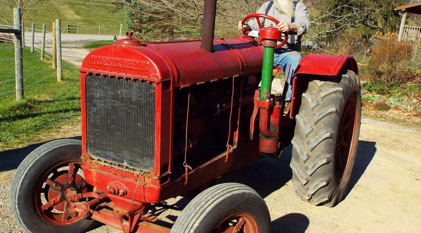 man on old red tractor