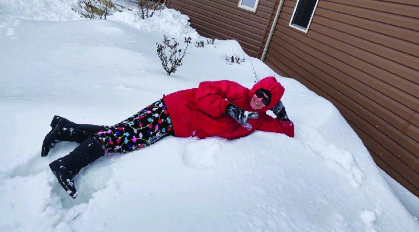 person in red jacket lying in the snow