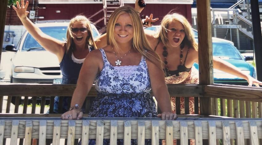 woman photobombed by two women behind