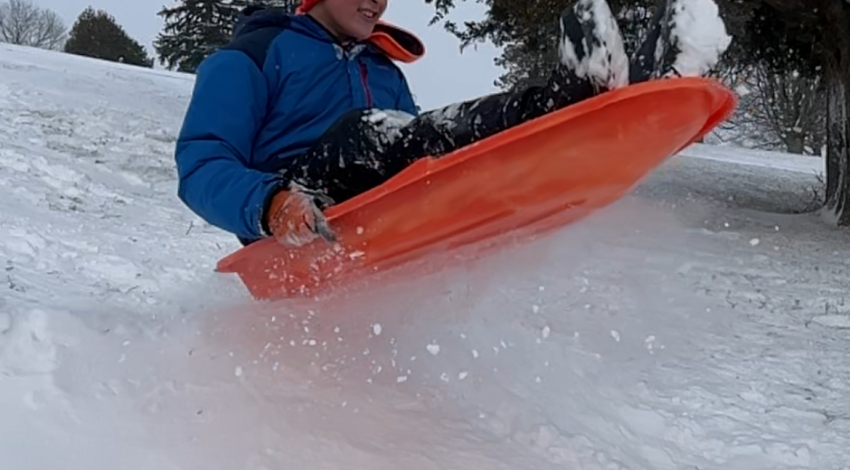 child flying on sled