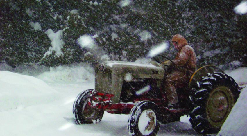 man on tractor in snow