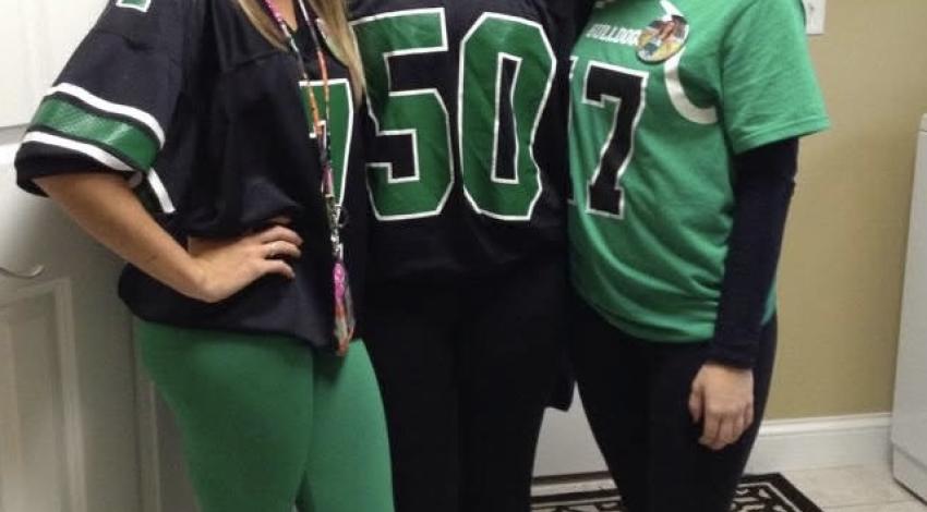 three girls standing with man looking through window behind
