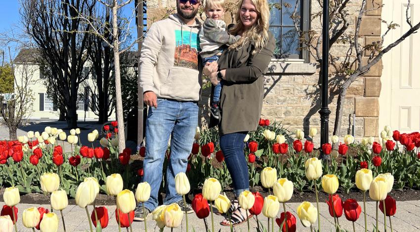 man, woman, and baby among tulips