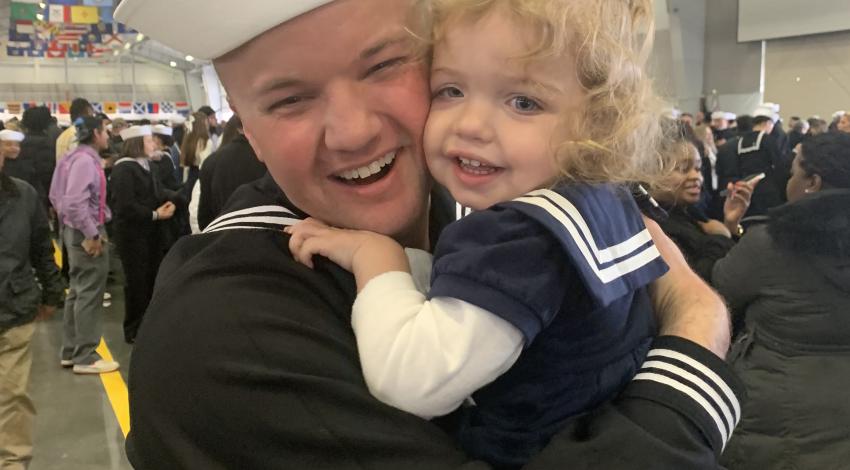man in sailor uniform hugging little girl in sailor dress