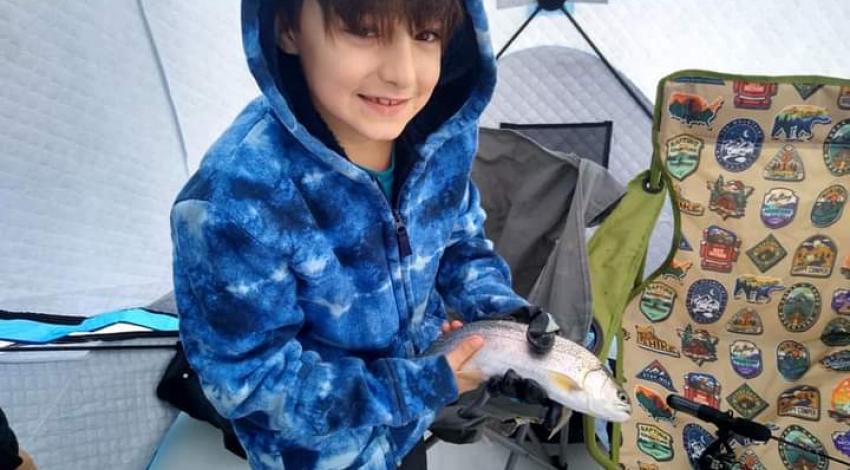 boy smiling holding a fish