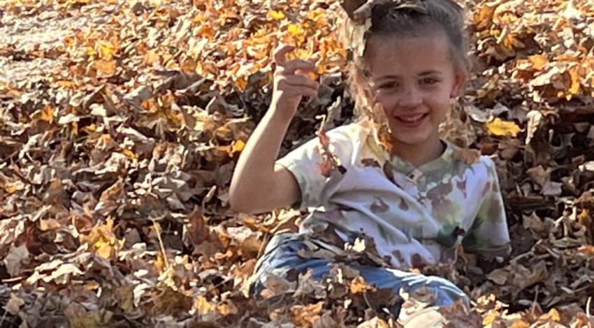girl in leaf pile