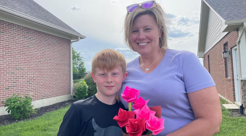 boy with woman holding pink flowers