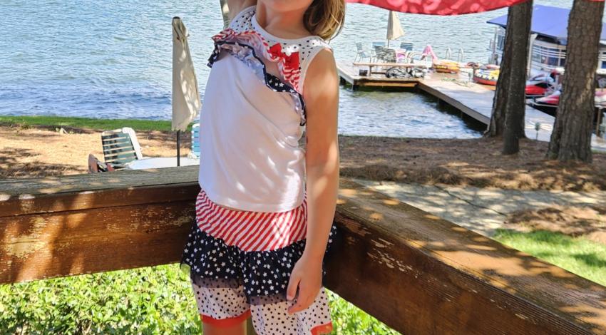 girl in red-white-and blue outfit holding American flag