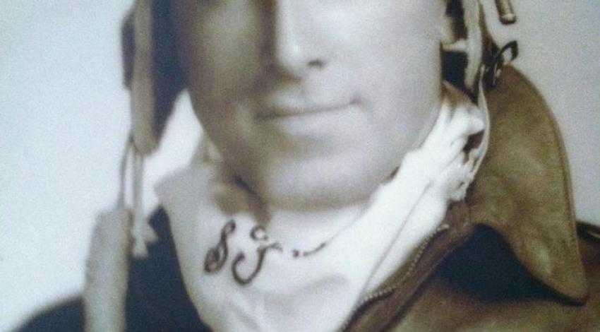 young man in pilot uniform with goggles on head