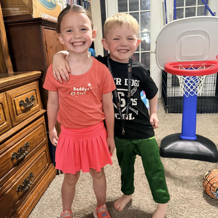 little boy with arm on little girl's shoulder